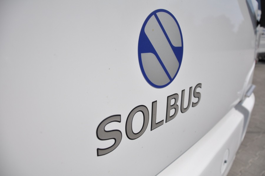 Zbliżenie na przód białego autokaru, widoczne logo SOLBUS.