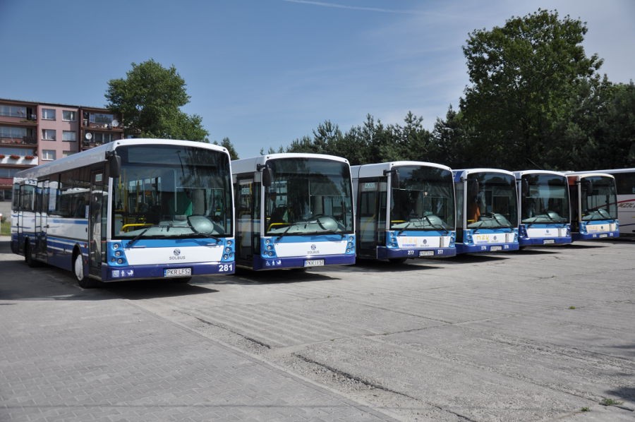 Prezentacja biało-niebieskich autobusów Solaris, sześć autobusów stojących obok siebie. Widoczny przód pojazdów.