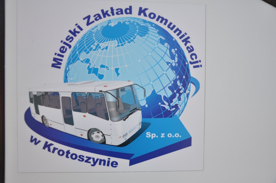 Logo Miejski Zakład Komunikacji w Krotoszynie Sp. z o.o. - biały autokar na niebieskiej strzałce, w tle kula ziemska