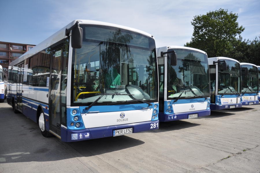 Prezentacja biało-niebieskich autobusów Solaris, cztery autobusy stojące obok siebie. Widoczny przód pojazdów.