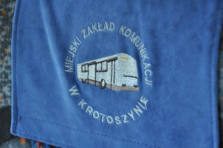 Niebieska narzuta na zagłówek fotela z wyszytym logo MZK w Krotoszynie